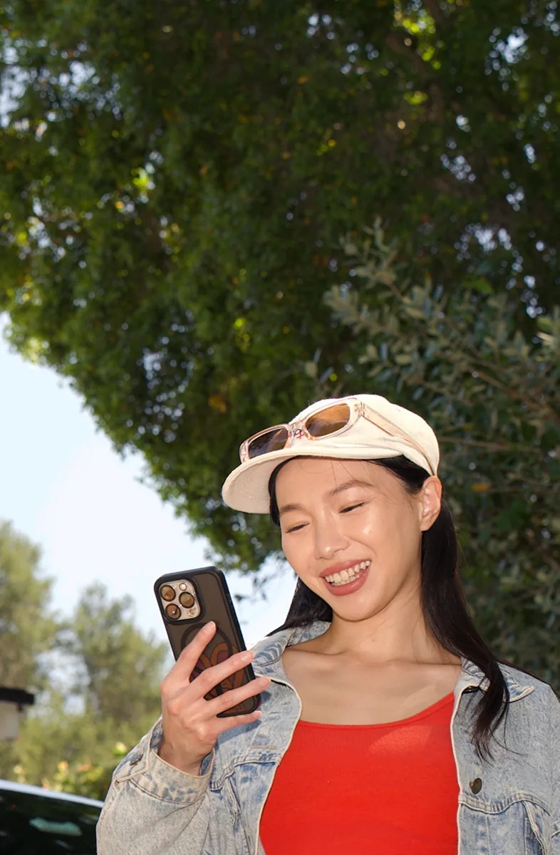 Seller checking her Bidbus offer beside a white car